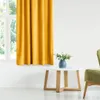 A living room scene with a yellow curtain, a white coffee table with a blue vase and flowers, and a green armchair. Produktbild-Vorschau