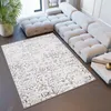 A modern living room with a sectional sofa and a patterned rug.