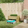 A robot lawnmower is parked under a wooden planter box next to a wooden fence. Podgląd zdjęcia produktu