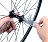 A person's hands are holding a digital caliper to measure the hub of a bicycle wheel. Produktbild-Vorschau