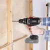 A person is using a cordless drill to drill a hole in a wooden wall. Produktbild-Vorschau