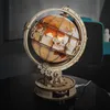 A wooden globe model with illuminated continents sits on a dark reflective surface. Náhľad obrázku produktu