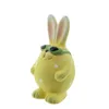 A yellow ceramic bunny figurine with sunglasses and white polka dots. Produktbild-Vorschau