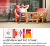 A man relaxing in a chair on a patio, with a heater emitting red light. Produktbild-Vorschau