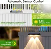 A split image showing solar-powered fence lights. The top half shows the lights on a white fence in daylight with text about charging speed. The bottom half shows the lights illuminating a gray fence at night with text about working time. Produktbild-Vorschau