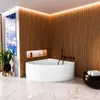A modern bathroom with a corner bathtub, wooden wall paneling, and ambient lighting. Produktbild-Vorschau
