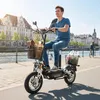 A man rides an electric scooter along a waterfront promenade with buildings in the background. Náhled obrázku produktu