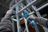 A person is using a cordless ratchet wrench to assemble a metal structure. Produktbild-Vorschau