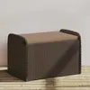 A brown poly rattan storage bench with a tan cushion is placed on a wooden deck against a light gray wall. Produktbild-Vorschau