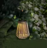 A solar-powered lantern hanging from a tree branch at dusk. Náhled obrázku produktu