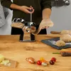 A person is using a pasta maker to make pasta dough on a wooden table with ingredients like carrots, onions, and tomatoes. Anteprima dell’immagine prodotto