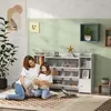 A mother and daughter are reading a book together on the floor in front of a white toy shelf. Náhled obrázku produktu