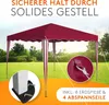 A red canopy tent set up in a grassy outdoor area with trees in the background. Produktbild-Vorschau