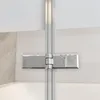 A close-up view of a shower hinge on a glass shower door, mounted on a wall above a bathtub. Produktbild-Vorschau