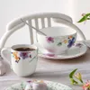 A table setting with a mug of coffee and a bowl and saucer, decorated with floral patterns. Podgląd zdjęcia produktu