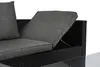 A close-up view of a section of a black rattan outdoor sofa with gray cushions. One cushion is partially lifted, revealing a storage compartment underneath. Produktbild-Vorschau