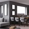 A modern living room and dining area with a sofa, dining table, chairs, and large windows. Produktbild-Vorschau