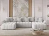 A modern, light gray U-shaped sectional sofa is arranged in a living room setting, facing a coffee table. The sofa is adorned with several matching throw pillows. Behind the sofa, a large abstract artwork with marble-like textures is displayed on a wall wi