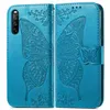A blue flip-style phone case with an embossed butterfly design is shown open, displaying the inside of the case and the exterior. Produktbild-Vorschau