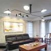 A living room scene with a black leather sofa, wooden coffee table, and a modern chandelier. Anteprima dell’immagine prodotto