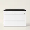 A white shoe cabinet with a black upholstered seat on top, shown against a plain background. Produktbild-Vorschau