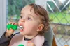 A toddler is eating with a spoon. Voir les images du produit
