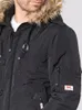 Close-up of a man wearing a black hooded winter jacket. Náhled obrázku produktu