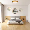 A bedroom scene with a bed, nightstands, and decorative mirrors on the wall, illuminated by a ceiling light. Produktbild-Vorschau