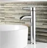 A close-up shot of a modern chrome faucet above a white sink, with a textured stone tile wall in the background. Náhľad obrázku produktu
