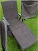 A gray terrycloth chaise lounge cover with a side pocket is draped over a lounge chair on a grassy lawn. Produktbild-Vorschau