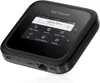 A black NETGEAR Nighthawk M6 Pro mobile hotspot is shown against a white background, displaying its screen with various menu options. Anteprima dell’immagine prodotto