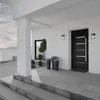 A modern house entrance with a black door, outdoor lights, and potted plants. Anteprima dell’immagine prodotto