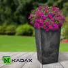 A tall, dark gray planter filled with vibrant pink flowers sits on a wooden surface, with a blurred green garden background. Produktbild-Vorschau