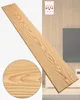 A wooden plank is shown diagonally across the image, with a close-up inset of the wood grain. The background shows a modern interior with wood paneling and furniture. Anteprima dell’immagine prodotto