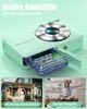 A digital camera with its battery compartment open, showing the battery. Below are two smaller images, one showing a family playing outside and the other showing a girl posing. Produktbild-Vorschau