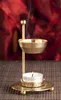 A brass incense burner with a lit candle underneath, producing smoke. Náhled obrázku produktu