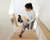 A woman is vacuuming a wooden staircase with a dog nearby. Anteprima dell’immagine prodotto