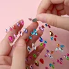 Hands applying colorful jewel stickers to a clear sheet. Produktbild-Vorschau