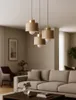 A modern living room with a beige sofa and a set of three pendant lights hanging above a coffee table. Produktbild-Vorschau