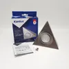 A product shot of a triangular LED under-cabinet light fitting, its packaging, and instructions, set against a white background. Náhled obrázku produktu