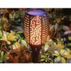 A solar-powered garden torch with a flame effect is shown in a garden setting, surrounded by plants and foliage. Produktbild-Vorschau
