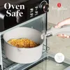A hand is shown placing a pot of food into an oven. The oven has controls and a brand logo visible. Produktbild-Vorschau