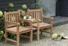 Two wooden chairs are placed on a patio with plants in the background. Produktbild-Vorschau