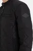 A close-up view of a black quilted jacket. Produktbild-Vorschau