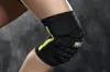 A close-up shot of a person's knee wearing a black and yellow knee brace. Produktbild-Vorschau