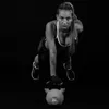 A woman is performing a kettlebell exercise in a black studio. Podgląd zdjęcia produktu