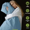 A woman is holding a light blue pillow and blanket, with marketing icons and text on the right side. Produktbild-Vorschau
