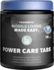 A product shot of Dometic Power Care Tabs in a black container with a blue lid, set against a dark, mountainous landscape background. Produktbild-Vorschau