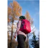 A person wearing a backpack walks through a forest with autumn trees. Anteprima dell’immagine prodotto
