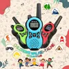 Three colorful walkie-talkies are displayed with cartoon children and outdoor activity icons. Voir les images du produit